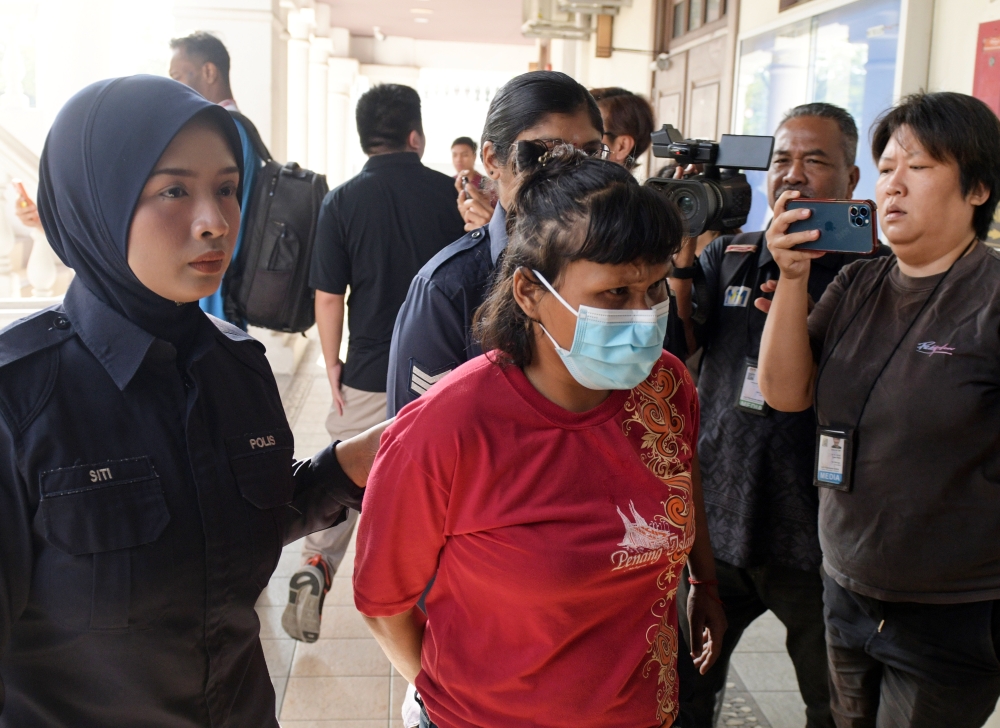 Halila Abu Bakar, 37, is escorted by police after being sentenced to 12 months’ jail by the Magistrate’s Court on Thursday. — Bernama file pic