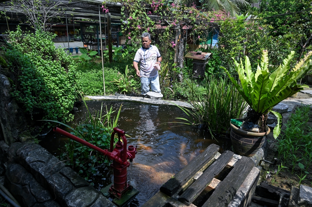Retired Royal Malaysian Navy veteran Hamdan Ahmad Sapli, 58, feeds fish at his home in Batu 10, Lekir, Lumut, on March 28, 2026. — Bernama pic