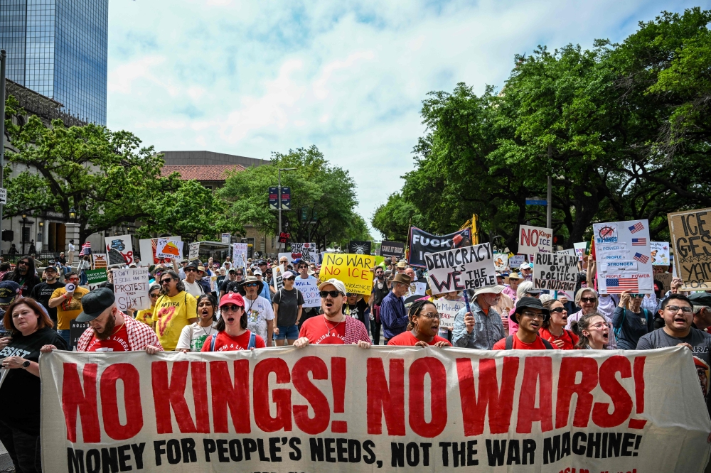 People holding signs march downtown in Houston on March 28, 2026 for the third time in less than a year as part of a grassroots movement called ‘No Kings’ in the most vocal and visual conduit for opposition to US President Donald Trump since he began his second term in January 2025. — AFP pic