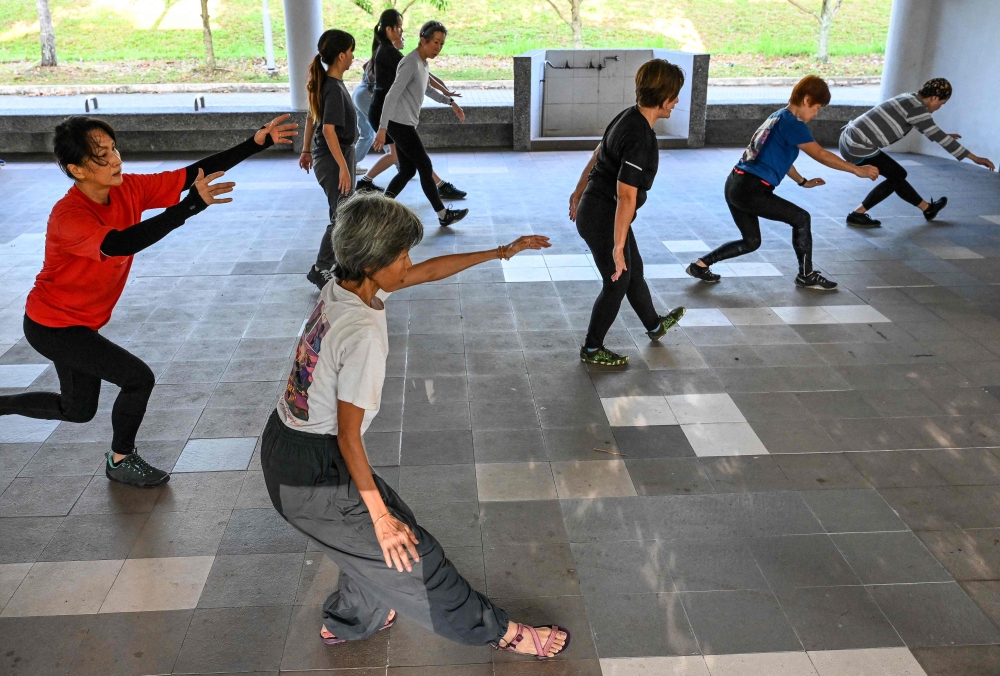 This photograph taken on March 17, 2026 shows Singaporean elders warming up before a parkour training session in Singapore. — AFP pic 
