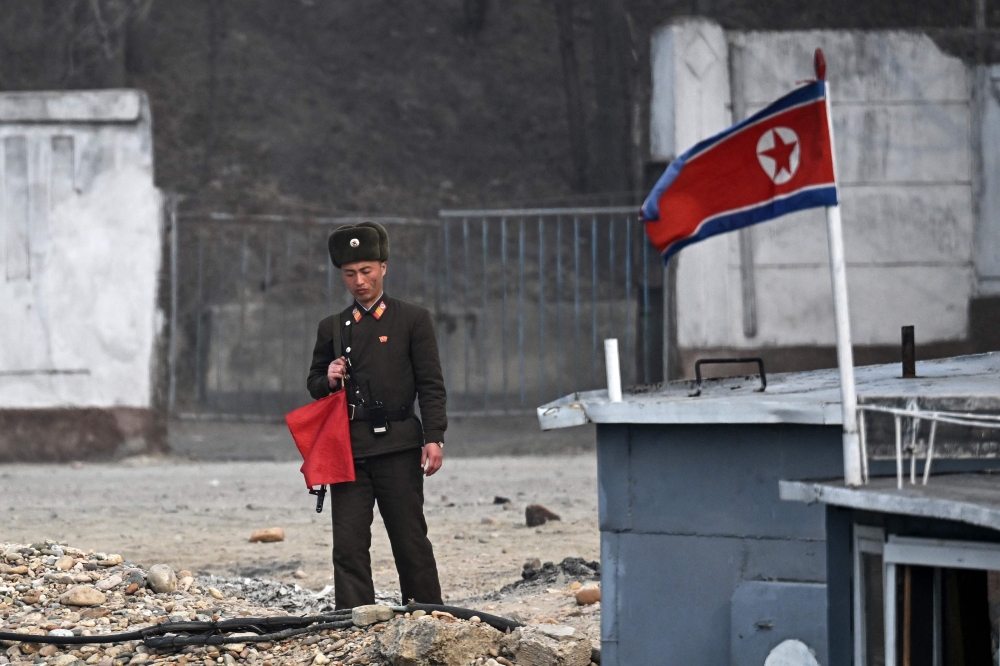 A North Korean soldier stands guard beside boats on the banks of the Yalu River in the North Korean town of Sinuiju, opposite the Chinese border city of Dandong in China’s northeastern Liaoning province on March 24, 2026. — AFP pic