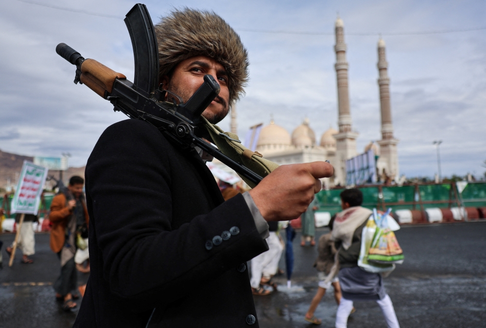 A man holding a weapon looks on during a demonstration of Houthi supporters in solidarity with Iran, as the US-Israeli conflict with Iran continues, in Sanaa, Yemen, March 27, 2026. — Reuters pic