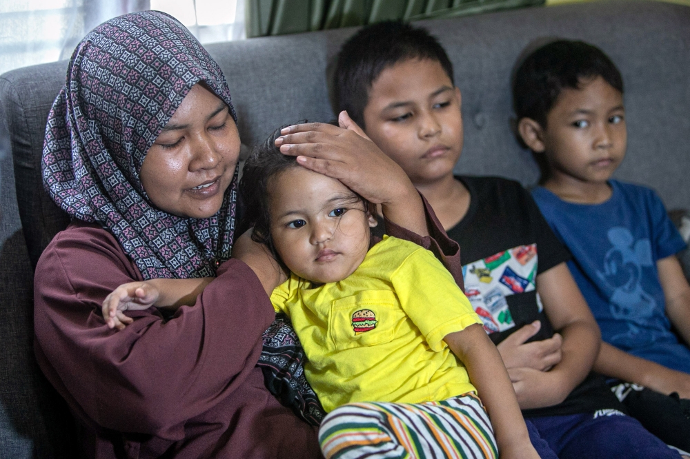 Widow of the late Amirul Hafiz Omar, 33, Nor Nadia Abdul Majid, 32, with her children Muhammad Aqif Amsyar, 9, Muhammad Atif Izz Rayqal, 7, and Nur Humaira, 2, at Kampung Repoh, Batu Kurau. — Bernama pic