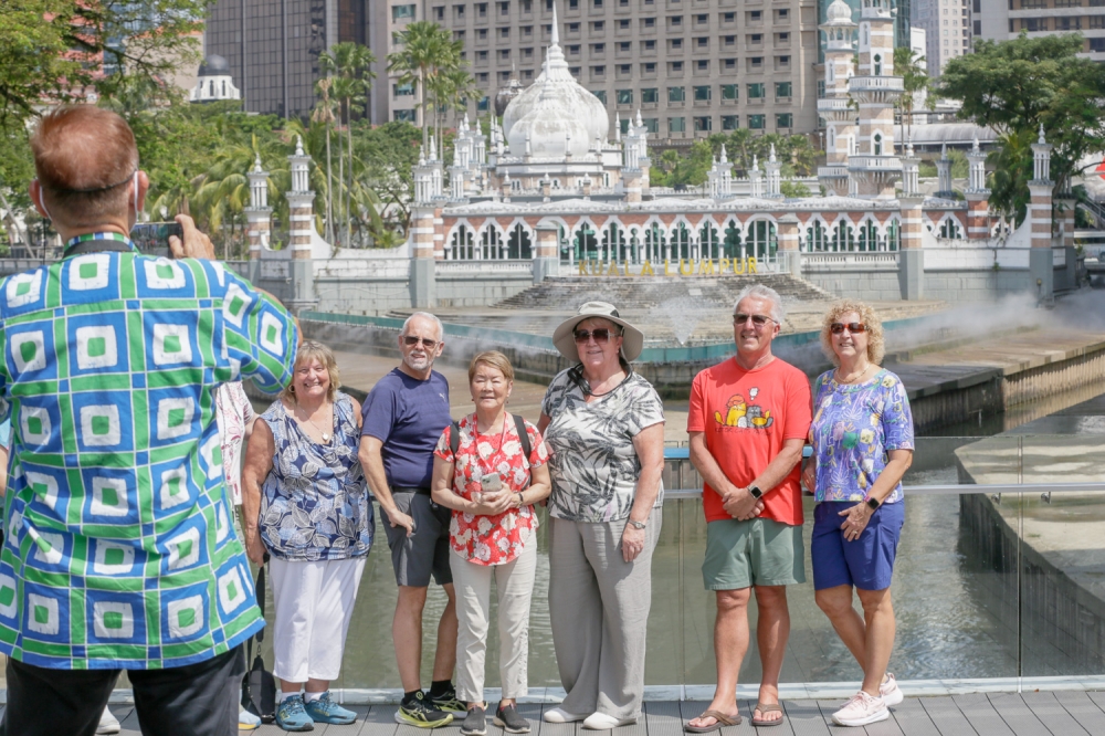 Guess where most of Malaysia’s overseas travellers come from. Tourists pose for a group photo at the River of Life area in Kuala Lumpur. — Picture by Raymond Manuel