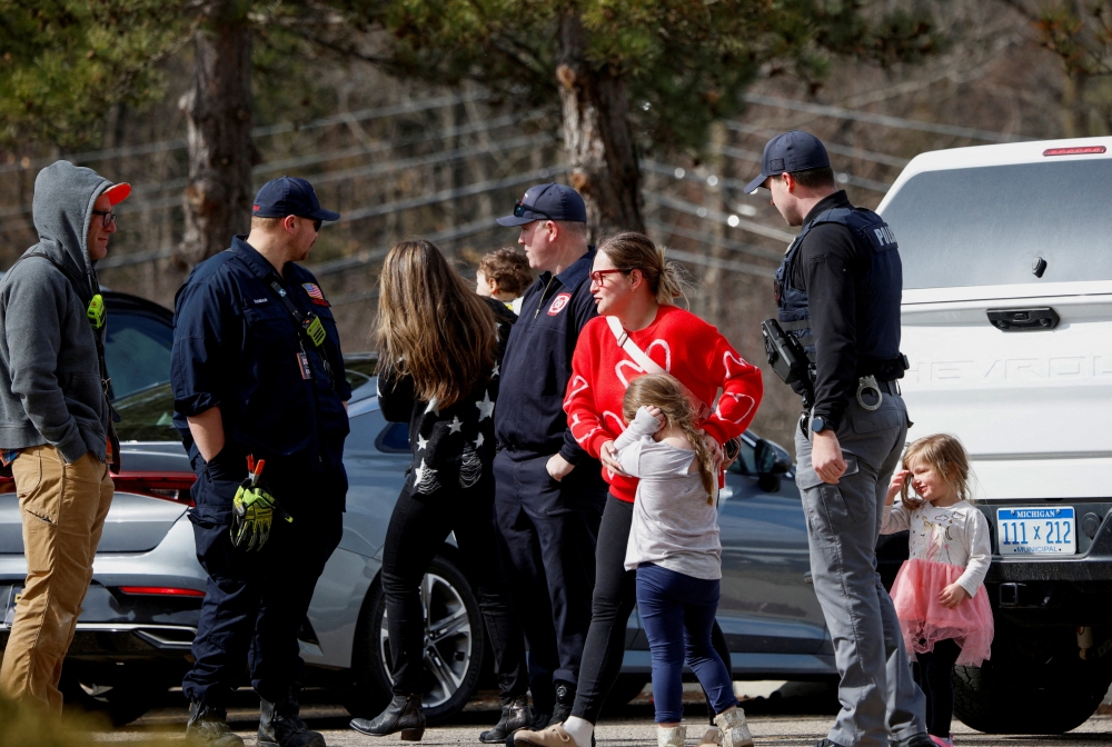 Parents who pulled out their kids from the Temple Israel Synagogue stand near police after the Michigan State Police reported an active shooting incident there, in West Bloomfield, Michigan March 12, 2026. — Reuters pic 