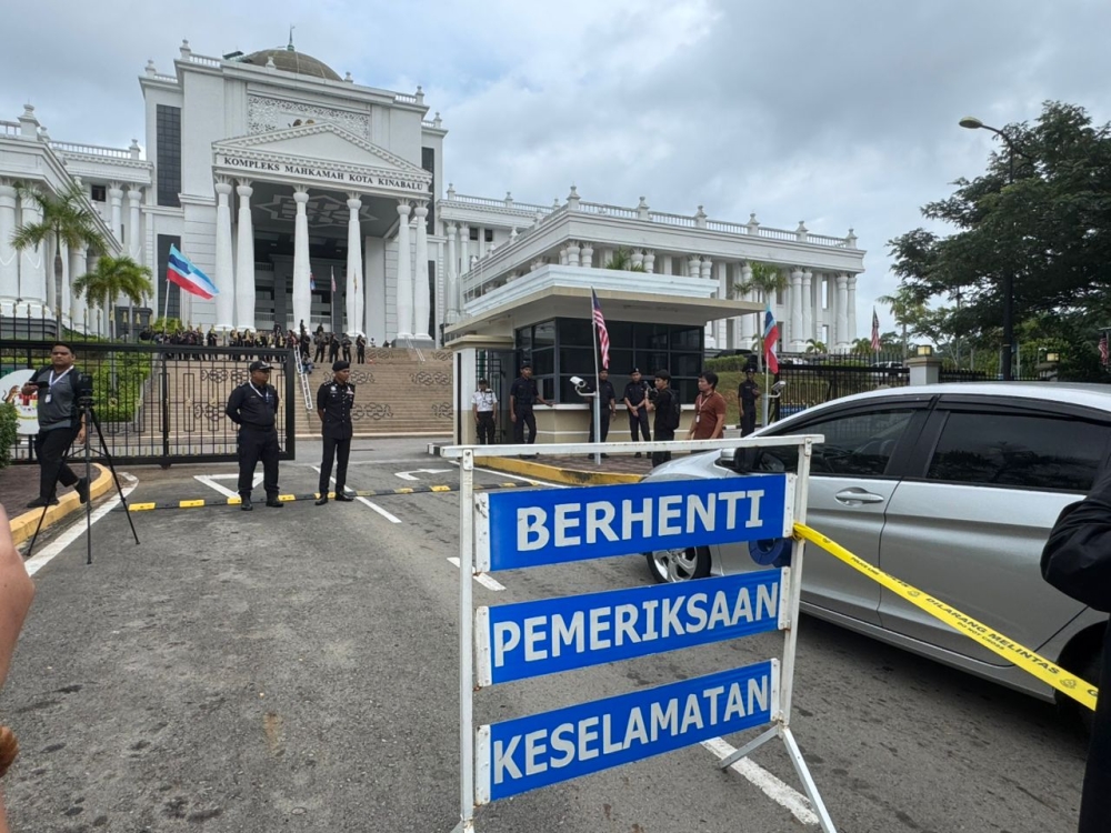 Police conduct security controls in front of the court complex in Kota Kinabalu. The inquest proceedings into the death of Zara Qairina Mahathir will continue with testimony from two more expert witnesses, comprising medical specialists, in sessions scheduled to take place in April. — Borneo Post pic