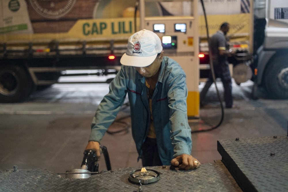 File picture of workers refuelling diesel at a gas station in Telok Panglima Garang, June 9, 2024. — Picture by Shafwan Zaidon