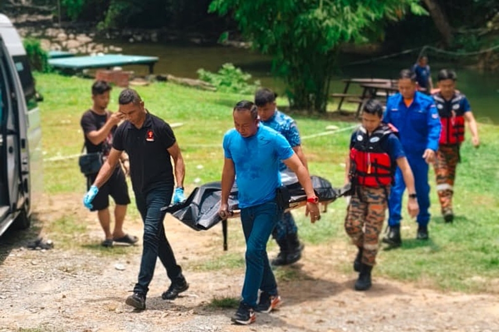 Firefighters carrying one of the victims bodies out from the campsite. — Picture courtesy of Fire and Rescue Department 