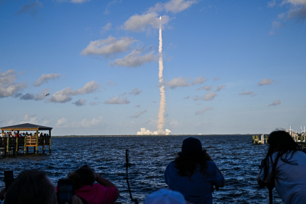 Space enthusiasts watch the Artemis II crewed lunar mission lift off from Kennedy Space Center from a park in Titusville, Florida, April 1, 2026. — AFP pic