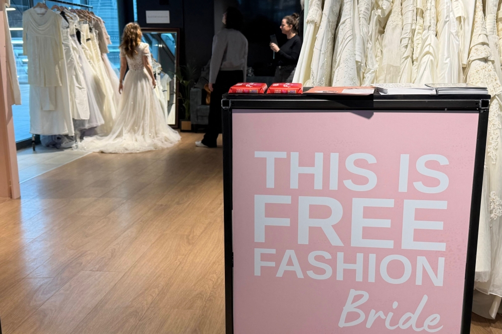 Sustainable development communications specialist and bride-to-be Lara Beters examines her second-hand wedding dress in a ‘Free Fashion’ pop-up shop shortly before her wedding inside Utrecht train station. — AFP pic 