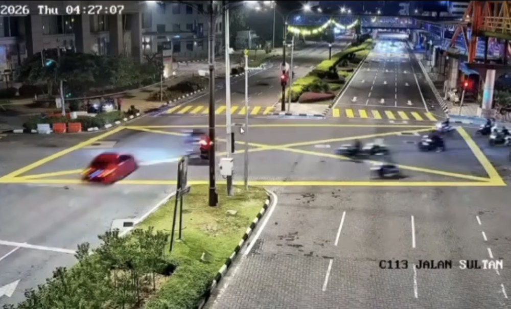 Screenshot from a CCTV footage circulating on social media of a red car (left) that ran a red light on Jalan Sultan Ismail towards Tuanku Abdul Rahman, Kuala Lumpur moments before impact with two motorcyclists on April 2, 2026. 