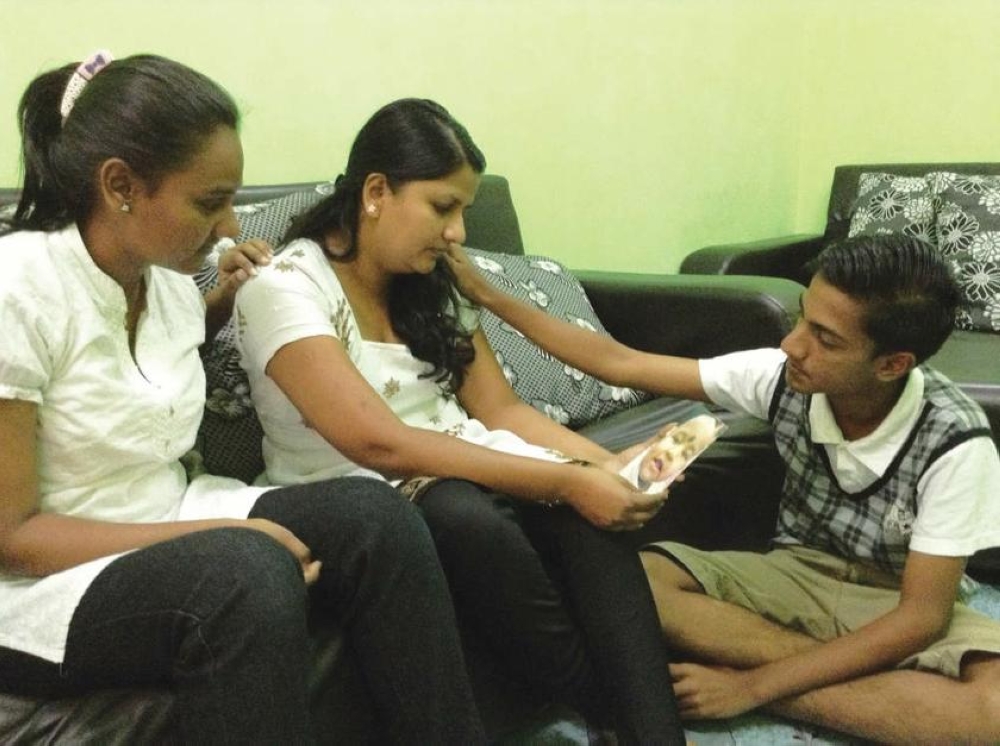 Tevi (left) and Karan comfort their mother Indira Gandhi, who is seen holding a photograph of Prasana Diksa. The last time they saw Prasana Diksa was in court when the child was one and a half years old, and they have never seen her since. — Malay Mail picture