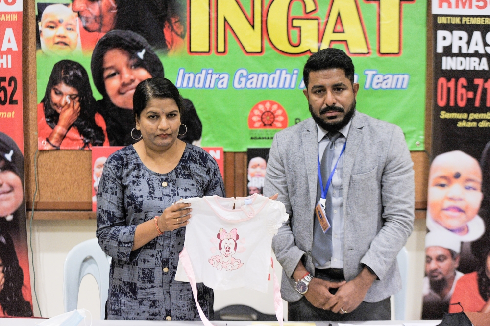 (from left) Indira Gandhi and Arun Dorasamy showing Indira Gandhi's daughter clothes at a press conference in Kuala Lumpur on October 9, 2020. — Picture by Shafwan Zaidon