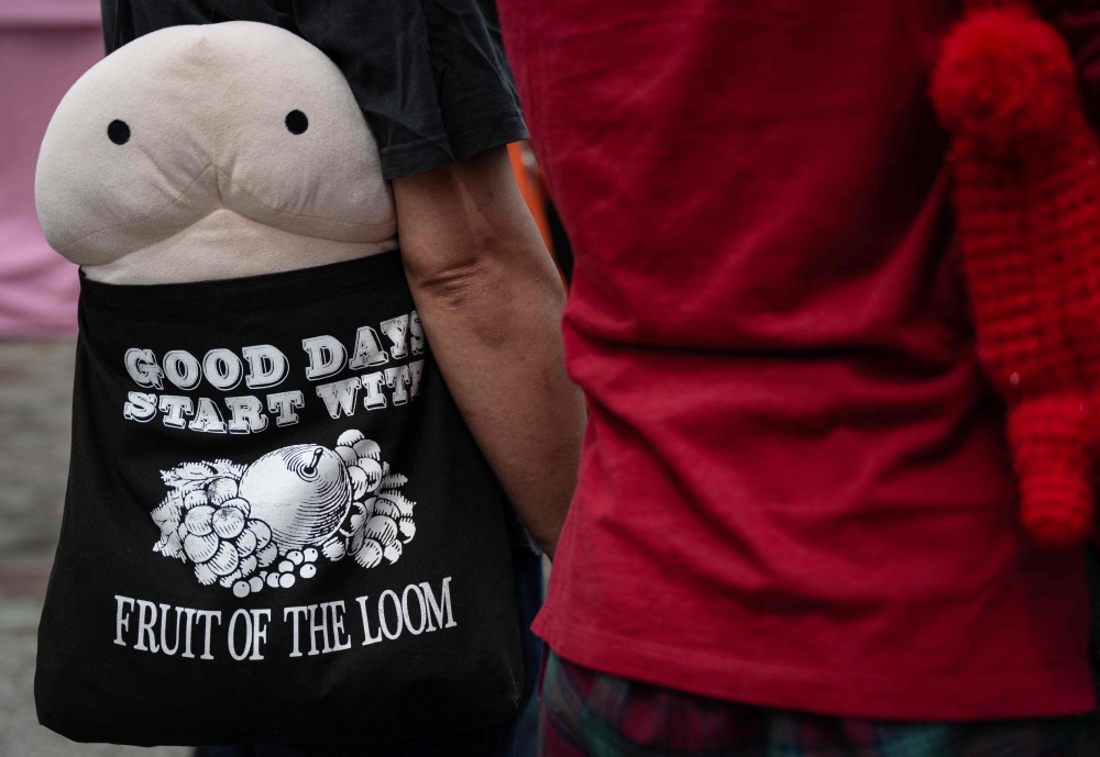A visitor carries a phallus-shaped doll in their bag during the Kanamara festival in Kawasaki on April 5, 2026. — AFP pic