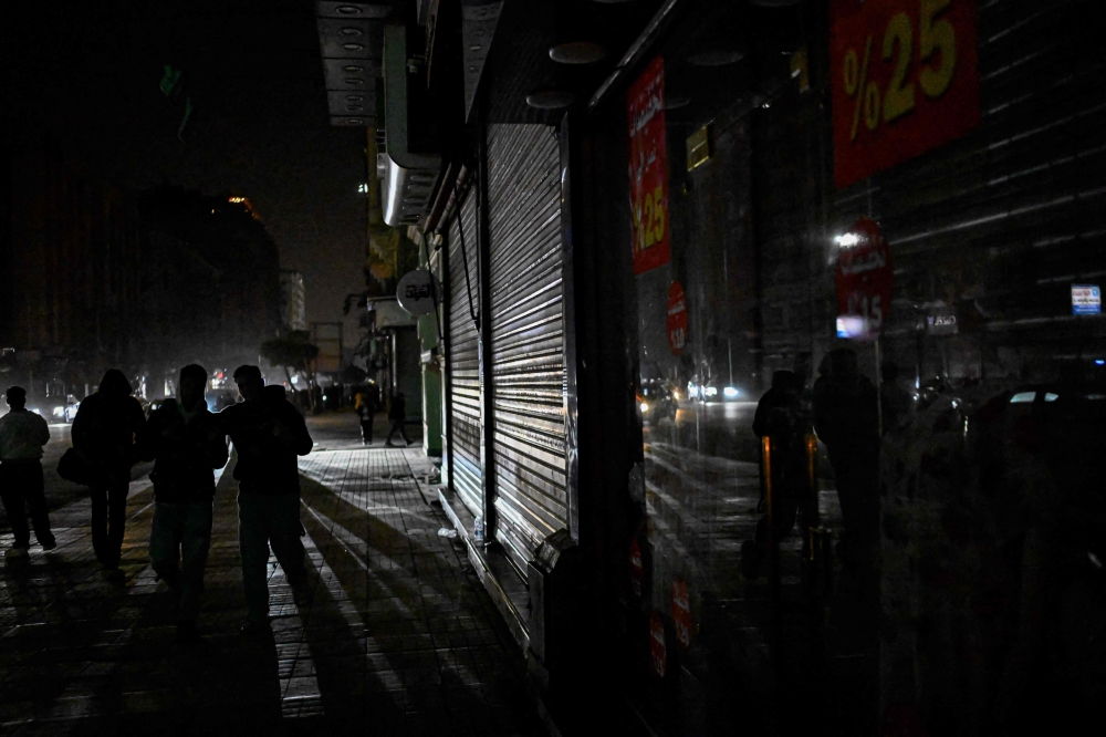 People walk in downtown Cairo after shops closed early under a government-ordered curfew aimed at reducing energy costs on April 2, 2026. — AFP pic
