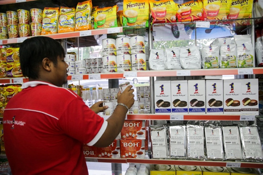 This file picture shows a Kedai Rakyat 1Malaysia (KR1M) store assistant stacking ‘1Malaysia’ brand products on shelves alongside other available brands on November 17, 2015. — Picture by Choo Choy May