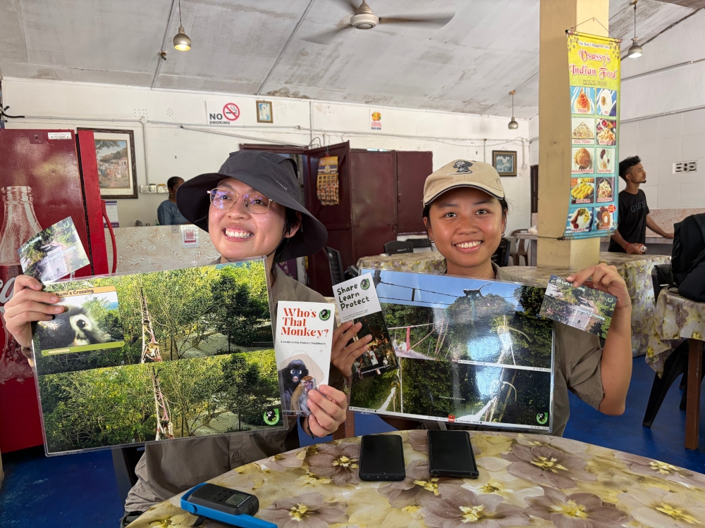 LPP founder Yap Jo Leen and project executive Wong Hui Yi (right) with pictures of the other two canopy bridges. — Picture by Opalyn Mok