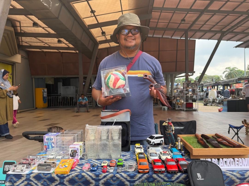 Collectibles and automotive accessories vendor Muhammad Azni Abu Bakar at his stall at Pasar Pagi. — Picture by Ben Tan