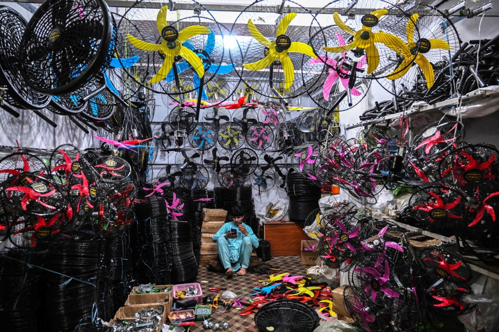 This photograph taken on April 4, 2026 shows a shopkeeper selling fans awaiting customers at a market in Rawalpindi as Pakistan faces energy supply chain disruptions amid the Middle East war. — AFP pic 