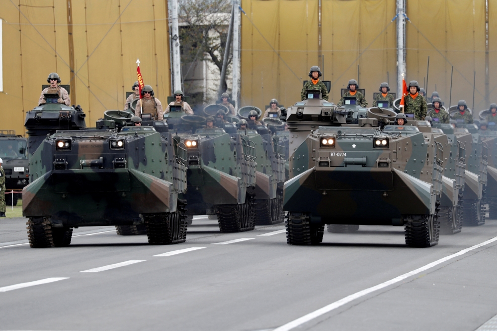 The US Army (left) and Japanese Self-Defence Forces’ (SDF) military vehicles parade during the annual SDF ceremony at Asaka Base in Asaka, north of Tokyo October 14, 2018. — Reuters pic  
