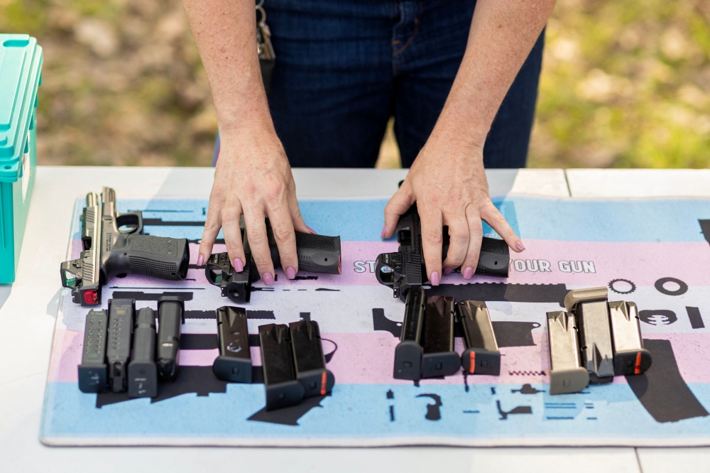An instructor arranges pistols and ammunition during an introductory firearms class at a backyard shooting range in Midlothian, Virginia, April 11, 2026. — AFP pic