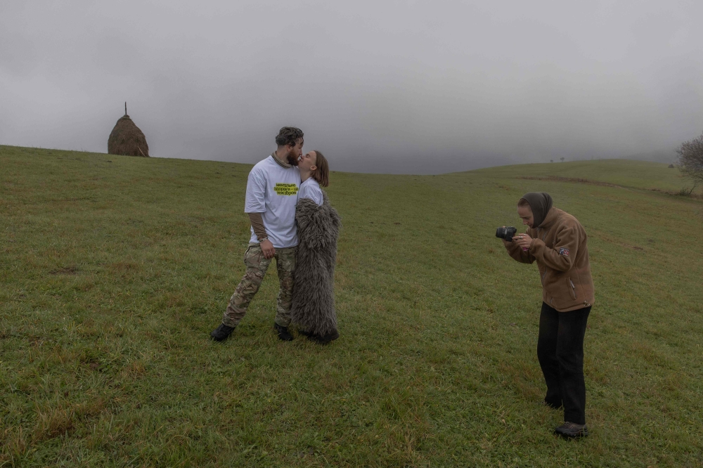Ukrainian combat medic Anastasia Podobailo, with her colleague and husband Mykola Yasinenko take part in a RePower programme photo shoot at the RePower programme, a mountain retreat designed to support Ukrainian military medics’ psychological recovery and mental well-being in Ukraine’s western Zakarpattia region on October 26, 2025. — AFP pic