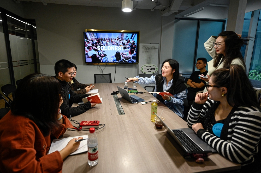 Founder of one-person company SoloNest Karen Dai (centre) shares her experience with participants during a coffee chat at a conference room in Shanghai on April 12, 2026. Young Chinese, many who fear age discrimination in their workplace after turning 35, are increasingly starting ‘one-person companies’ that have artificial intelligence do most of the work. — AFP pic