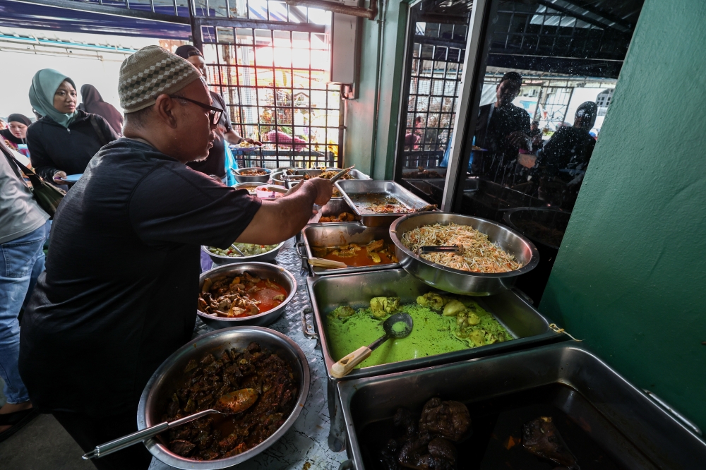 Anor Serat packs food ordered by customers. — Bernama pic 