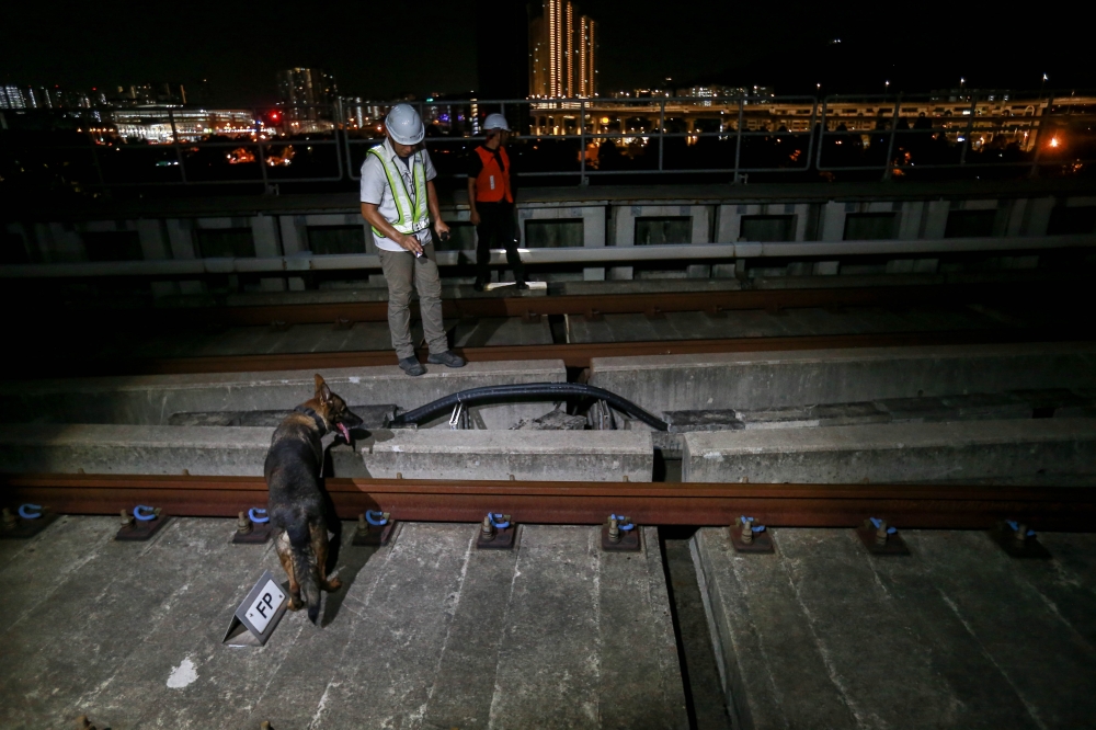 Yew and Tessy conducting track inspection between the Taman Naga Emas and Sungai Besi MRT stations for any signs of tampering or trespass by cable thieves. — Picture by Sayuti Zainudin
