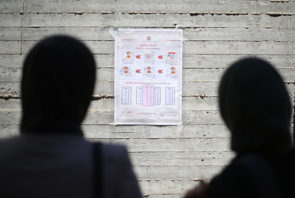 Women read instructions to voters ahead of the upcoming municipal elections in Deir el-Balah in the central Gaza Strip on April 21, 2026. — AFP pic 