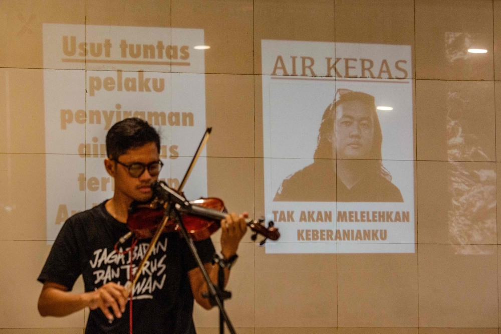 A local violinist performs during a demonstration in support of Andrie Yunus, a staff member of Indonesian human rights NGO KontraS (Commission for the Disappeared and Victims of Violence), who was attacked with acid by an unidentified person several days earlier, at Universitas Islam Indonesia (UII) in Yogyakarta on March 16, 2026. Indonesian police are hunting for four people wanted for an acid attack that maimed an activist critical of the military's growing role in government, an official said March 16. — AFP pic