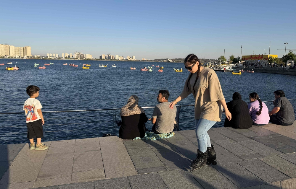 Iranians enjoy the waterfront at Chitgar Lake, an artificial recreational lake and park officially known as the Lake of the Martyrs of the Persian Gulf, in northwestern Tehran on April 26, 2026. — AFP pic