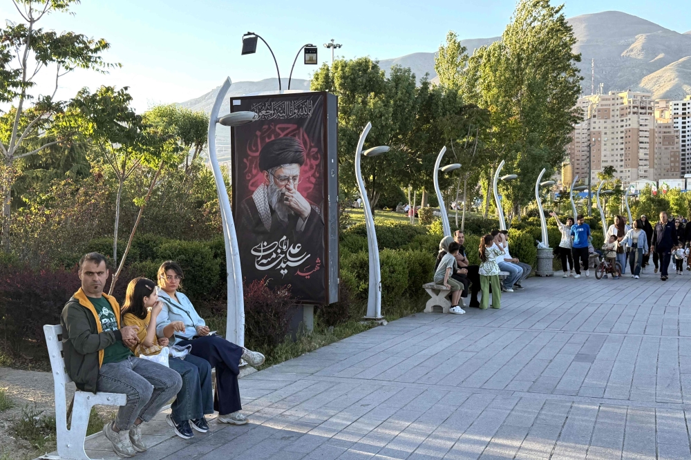 A banner reading ‘Martyr Ayatollah Ali Khamenei’ is displayed along the walkway at Chitgar Lake, an artificial recreational lake and park officially known as the Lake of the Martyrs of the Persian Gulf, in northwestern Tehran on April 26, 2026. — AFP pic