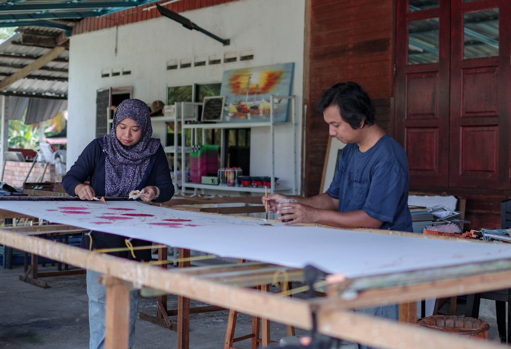 Nadia Mohd Fuzi, 39, and her husband, Haiyat Md Hassim, 47, work on ‘batik canting’ at Rumah Batik Sri Wangsa in Mersing, Johor recently. — Bernama pic