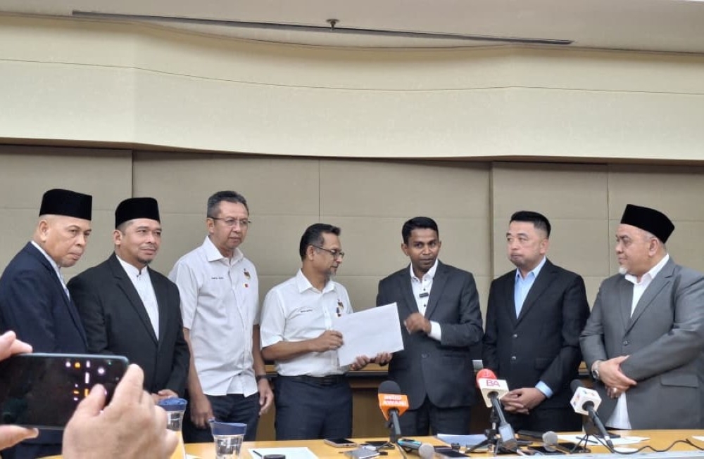 Perikatan Nasional’s Labu assemblyman Mohamad Hanifah Abu Baker (third from right) handing over a letter of cooperation to Negeri Sembilan Umno secretary Datuk Mustapha Nagoor during a press conference at the Royale Chulan Seremban hotel in Seremban April 27, 2026. — Picture by Ida Lim