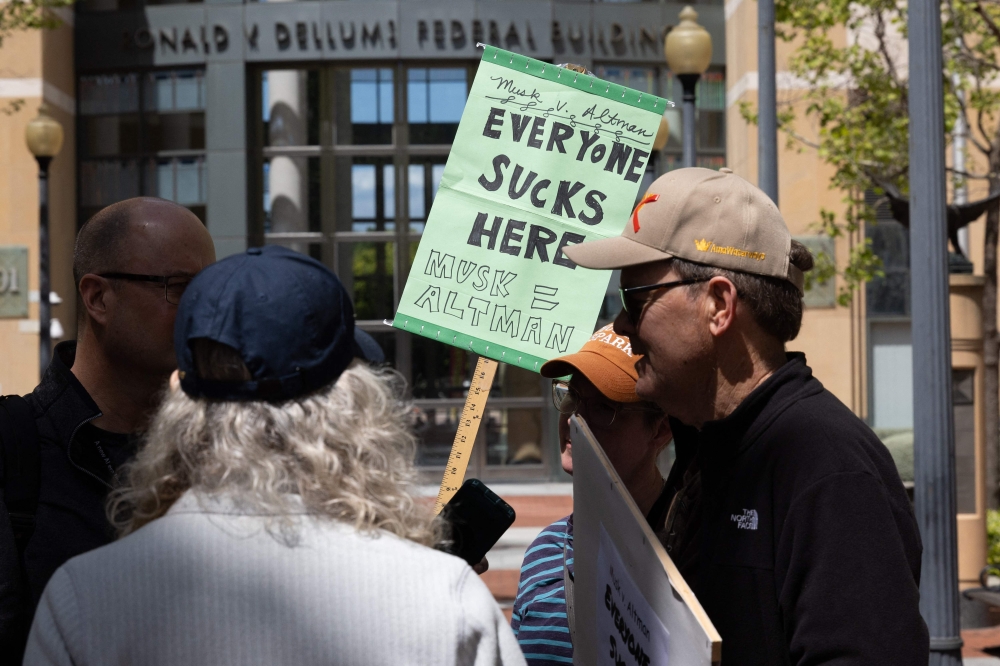 Demonstrators protest outside the courthouse at the Ronald V. Dellums Federal Building as jury selection begins in the lawsuit between Elon Musk and OpenAI in Oakland on April 27, 2026. — AFP pic