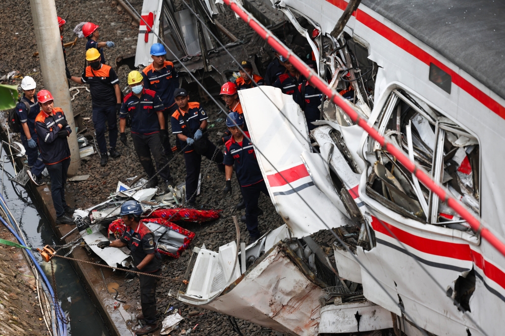 Technicians work at the site after a deadly collision between a commuter line train and a long-distance train in Bekasi on April 28, 2026. — Reuters pic