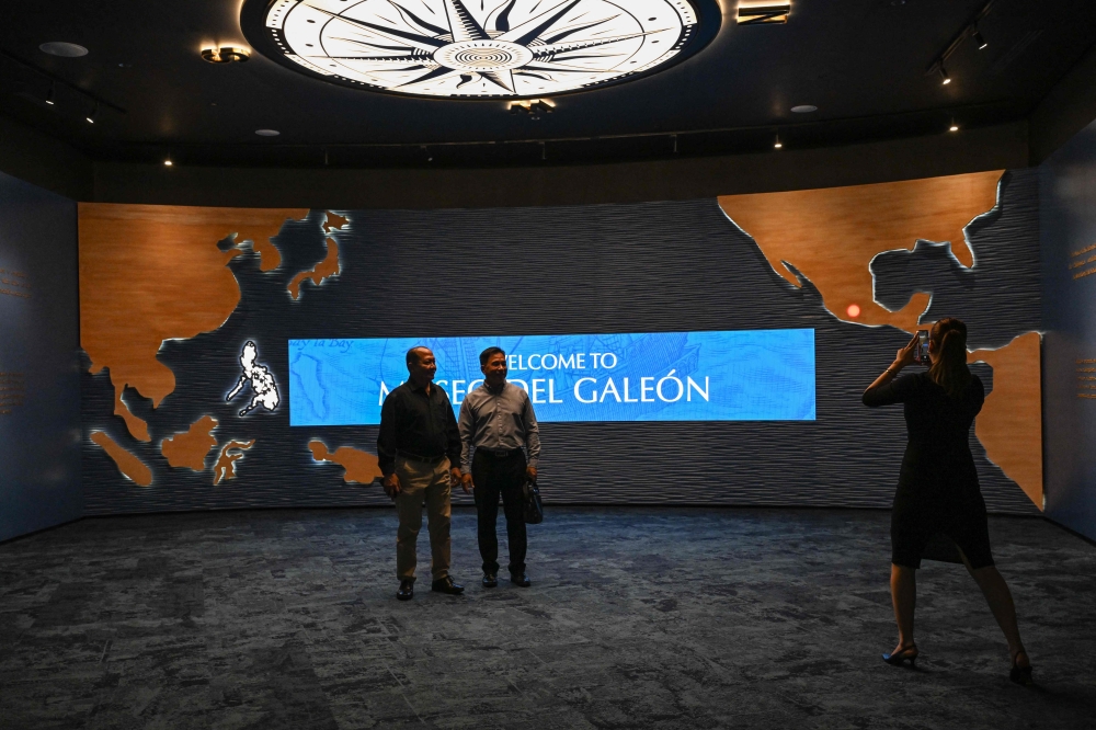 This photo taken on April 23, 2026 shows men posing for a photo at the Museo del Galeon in Manila. A full-size replica of a Spanish galleon stares out into Manila Bay, the centrepiece of a museum that will transport visitors back to the 17th century, when conscripted Philippine mariners birthed the era of globalisation. — AFP pic