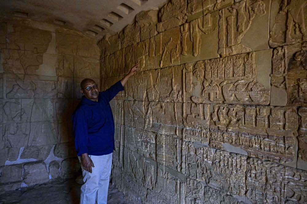 Sudanese site director Mahmoud Soliman gestures inside a tomb beneath a pyramid at one of the archaeological sites of the so-called Island of Meroe. — AFP pic