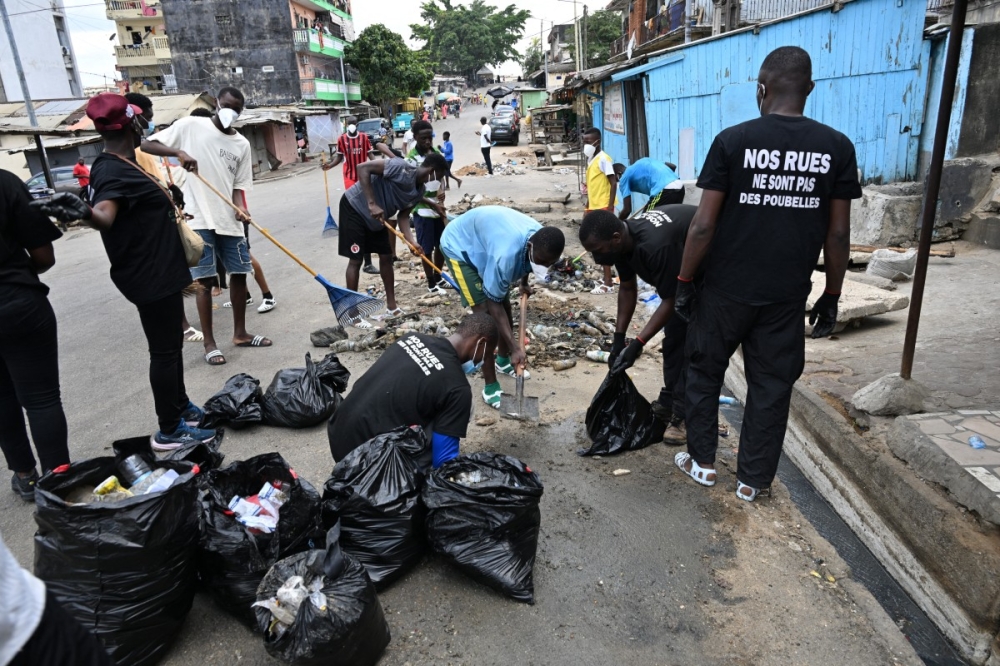 Young volunteers from the association called Clean Street scrub waste-clogged gutters overflowing with trash and other plastics in Attecoube, a popular district of Abidjan March 22, 2026. — AFP pic 