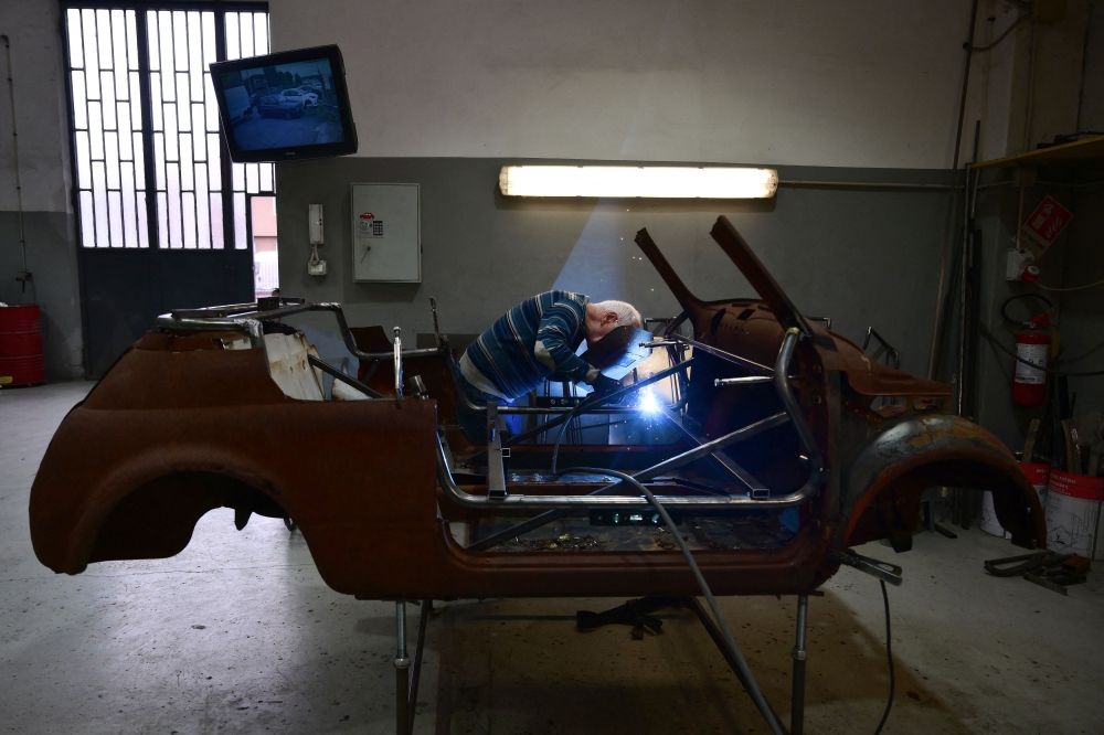 A worker welds the frame of an old Fiat 500 model that will be transformed into an electric 500 Jolly Lido model at the Officine Gentile garage in Turin on April 30, 2026. — AFP pic