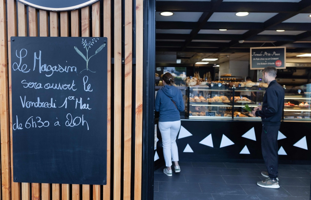Clients wait in line in a bakery in Quimper, western France, on May 1, 2026. — AFP pic