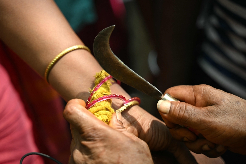 Thilothama, a tansgender, gets her bangles broken by a priest symbolising end of her marriage to Hindu warrior god Aravan during the annual Koovagam transgender festival at the Koothandavar temple in Tamil Nadu's Kallakurichi district. — AFP pic