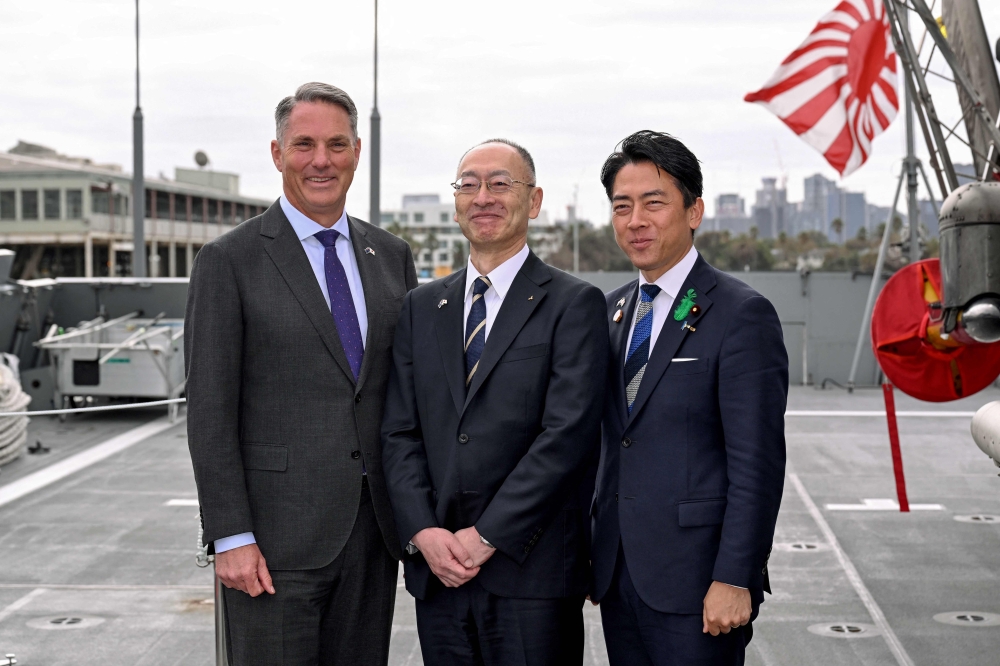 This file picture shows Australia’s Deputy Prime Minister and Minister for Defence Richard Marles (L) and Japan’s Minister of Defense Koizumi Shinjiro (R) posing for a photo with Eisaku Ito, Pesident and CEO of Mitsubishi Heavy Industries, before the signing of a contract for Japan to deliver the first three of Mogami-class warships, in Melbourne on April 18, 2026. — AFP pic