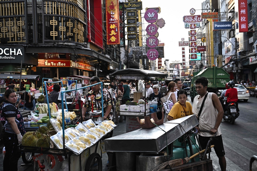 Pavements become battlegrounds for pedestrians and hawkers as street food sellers move their carts during the evening rush hour in Bangkok’s Chinatown. — AFP pic