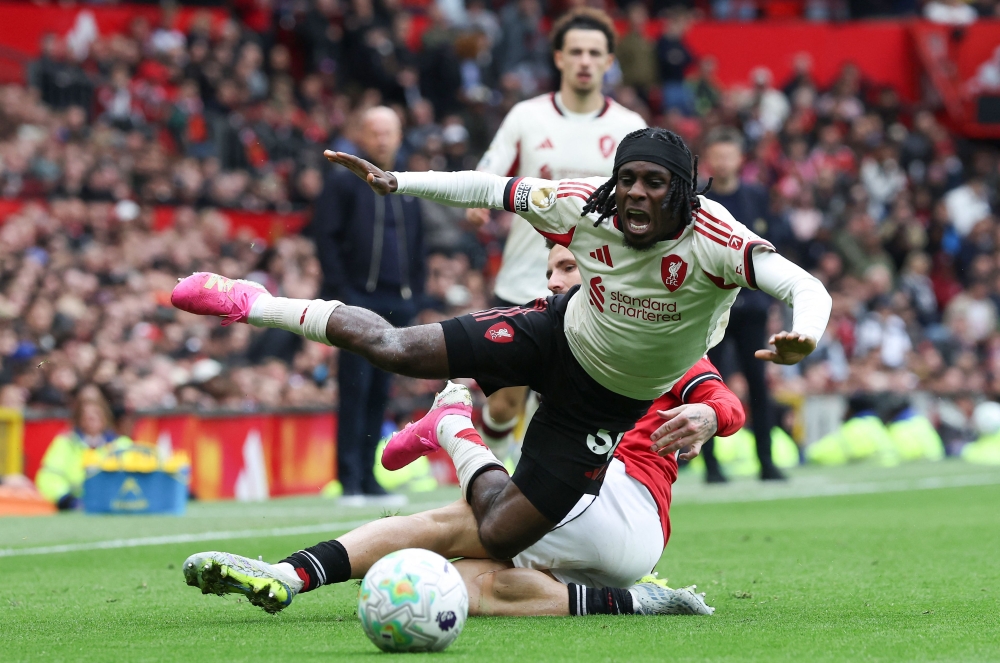 Manchester United’s English defender #23 Luke Shaw ® fouls Liverpool’s Dutch defender #30 Jeremie Frimpong during the English Premier League football match between Manchester United and Liverpool at Old Trafford in Manchester, north west England, on May 4, 2026. — AFP pic