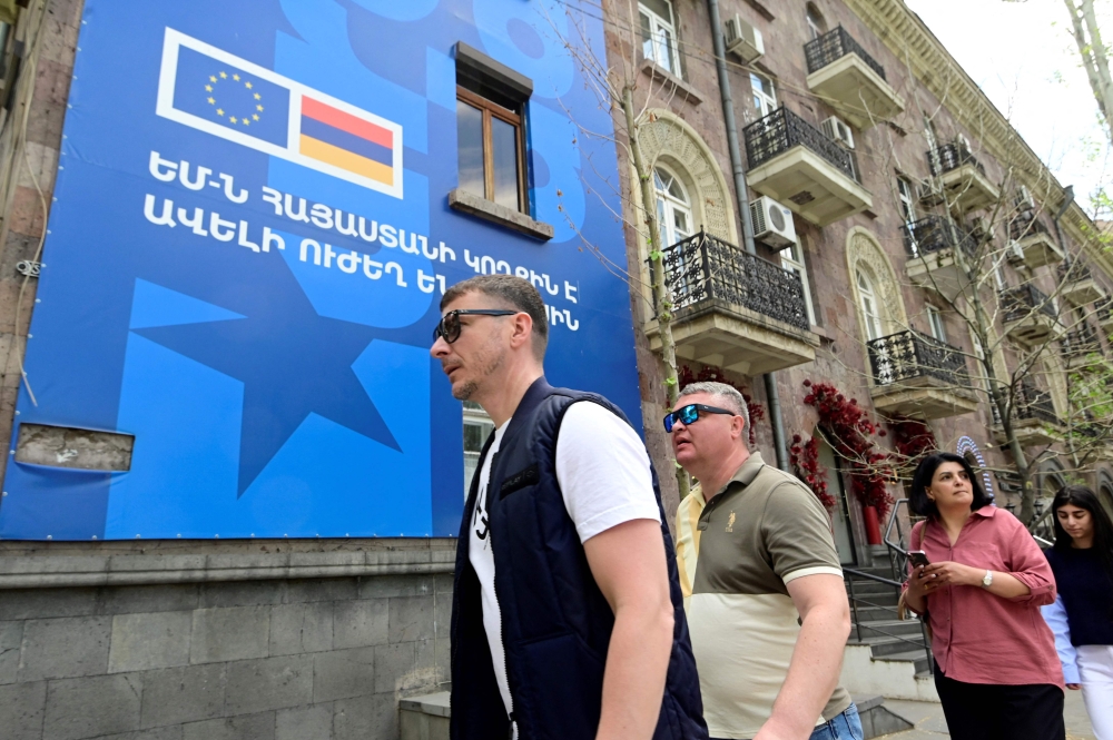 Pedestrians walk past a poster announcing the upcoming first EU泡rmenia Summit, in Yerevan on May 2, 2026. — AFP pic
