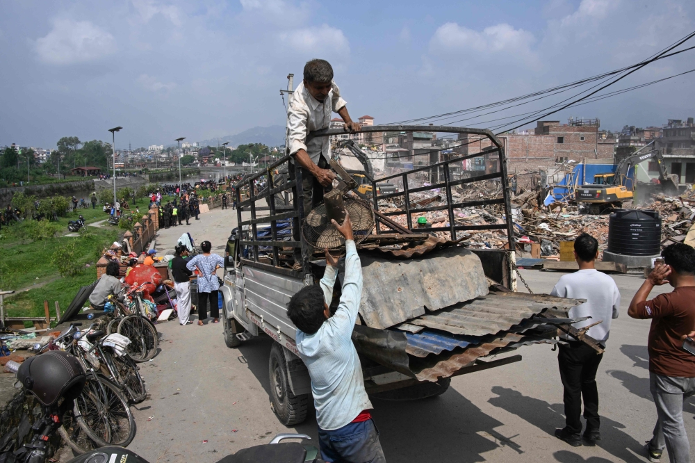 Men load their belongings on a truck as squatter settlements are demolished in Kathmandu on May 1, 2026. — AFP pic