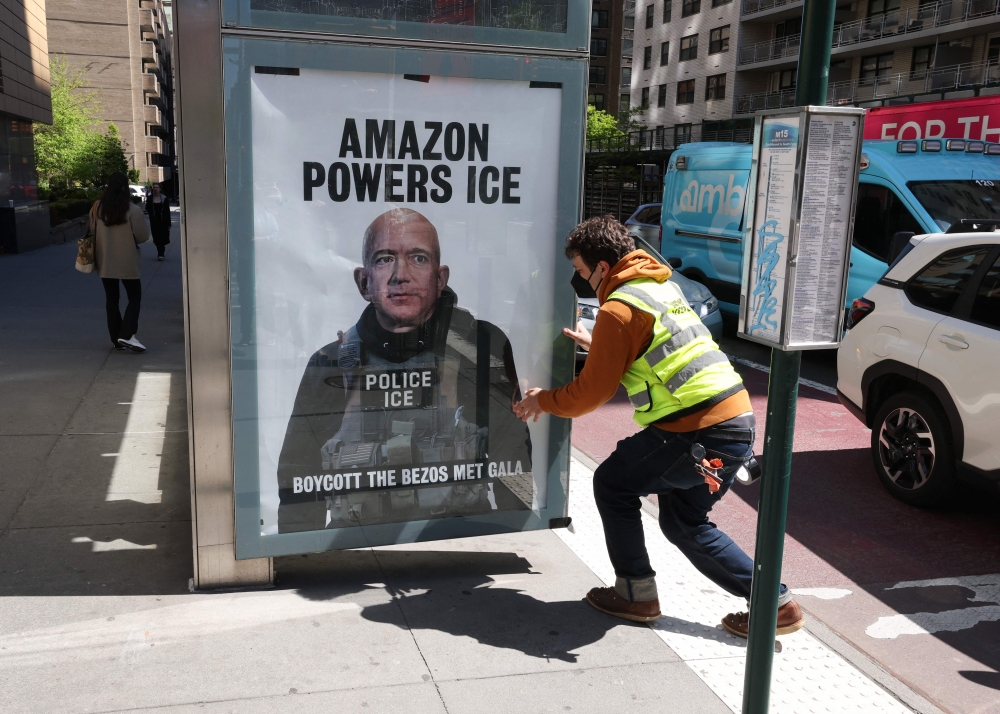 A man puts up a “Boycott the Bezos Met Gala” poster at a bus stop in the Manhattan borough of New York City on April 27, 2026. — AFP pic