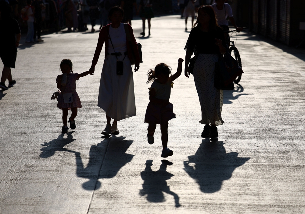 People with children walk in Tokyo, Japan on August 5, 2025. — Reuters pic